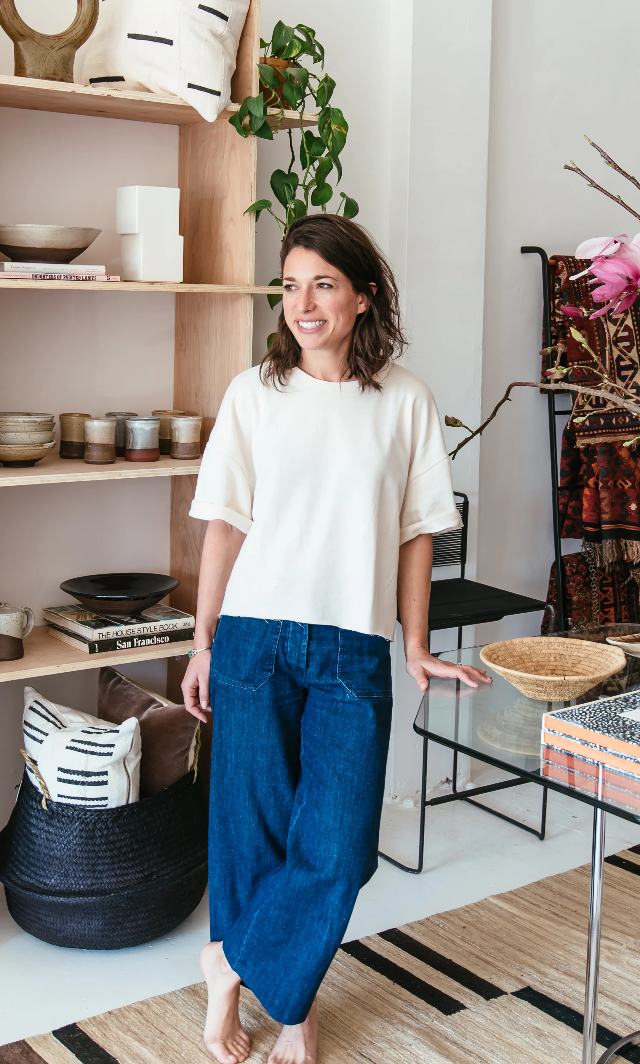 Portrait of Leah Harmatz, founder of Field Theory, standing in her design studio surrounded by curated ceramics, textiles, and natural materials.