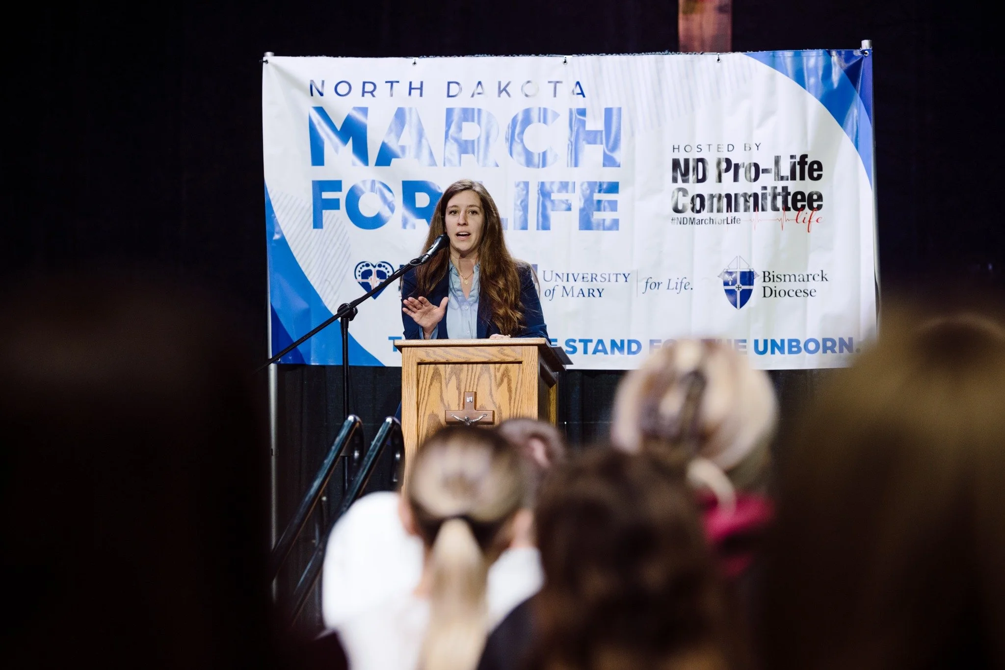 A speaker at the North Dakota March for Life with attendees in the foreground.
