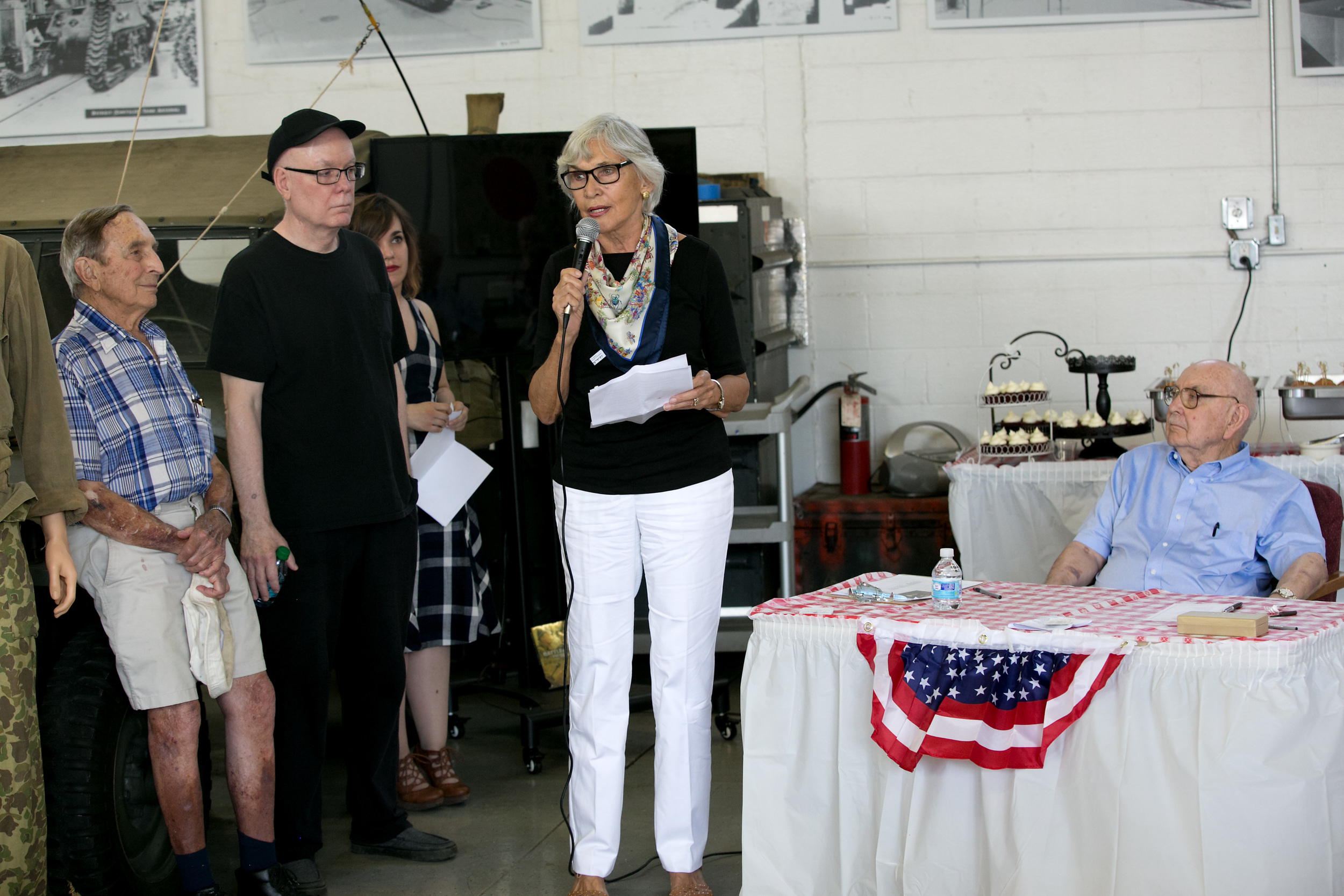 Margaret Pigott speaking long shot w Bob at table.jpg