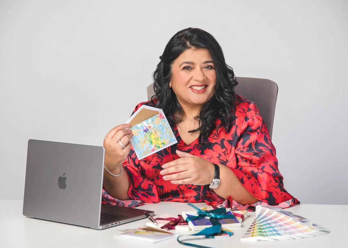 Vaishali Shah, owner of Ananya Cards, holding stationery and smiling at camera