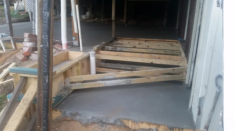 Original sloping concrete floor, internal brick and studwork removed, block levelled for two floors, formwork made, concrete poured and finished.