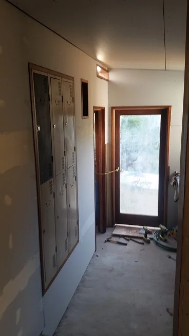 Flush mounted recycled lockers fitted into Meranti frame which was made on-site to suit, custom made flush mounted speaker frame, internal and external door & window frames made on-site and fitted, secondhand glass panel door fitted to custom made door frame.