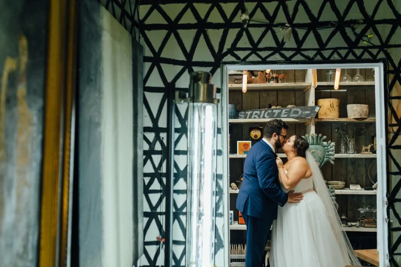 Wedding Kiss Portraits, Eclectic Wedding at Big Daddy's Antiques Los Angeles, Groom in a blue suit, Della Curva Bride, Art & Soul Events