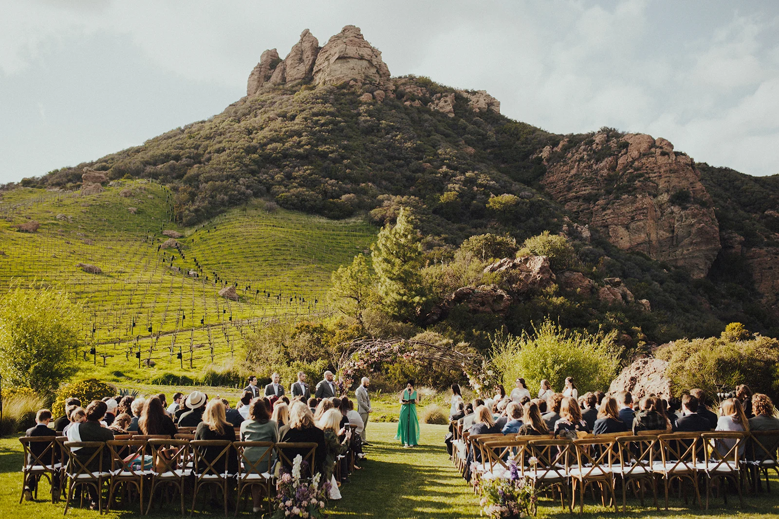 Gorgeous outdoor ceremony in front of a wood vine arch at Saddlerock Ranch Camp Cabernet Malibu Winery Wedding Venue, Planned by Art & Soul Events