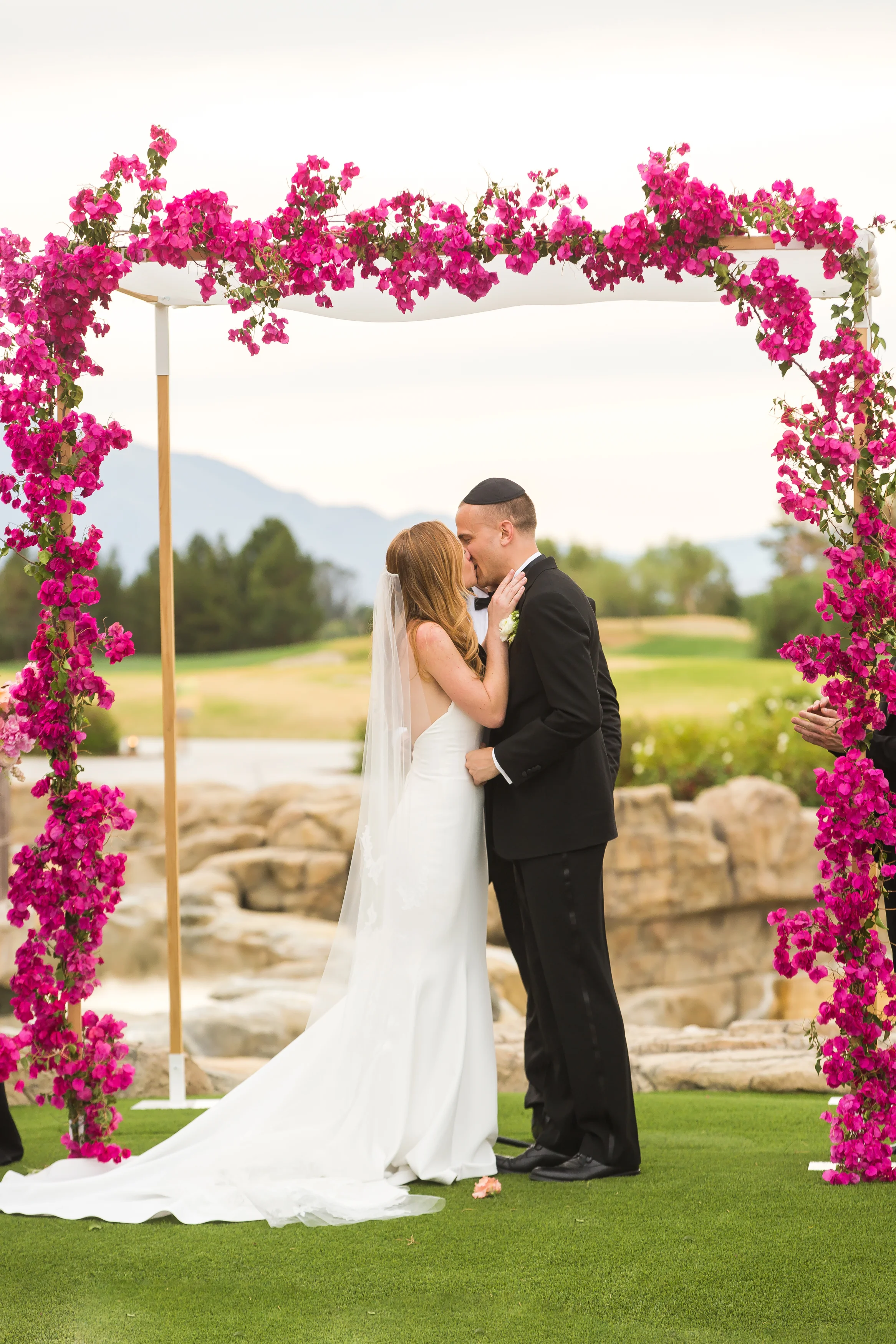 bride-groom-kiss-bougainvillea-chuppah-palm-springs-wedding.jpg