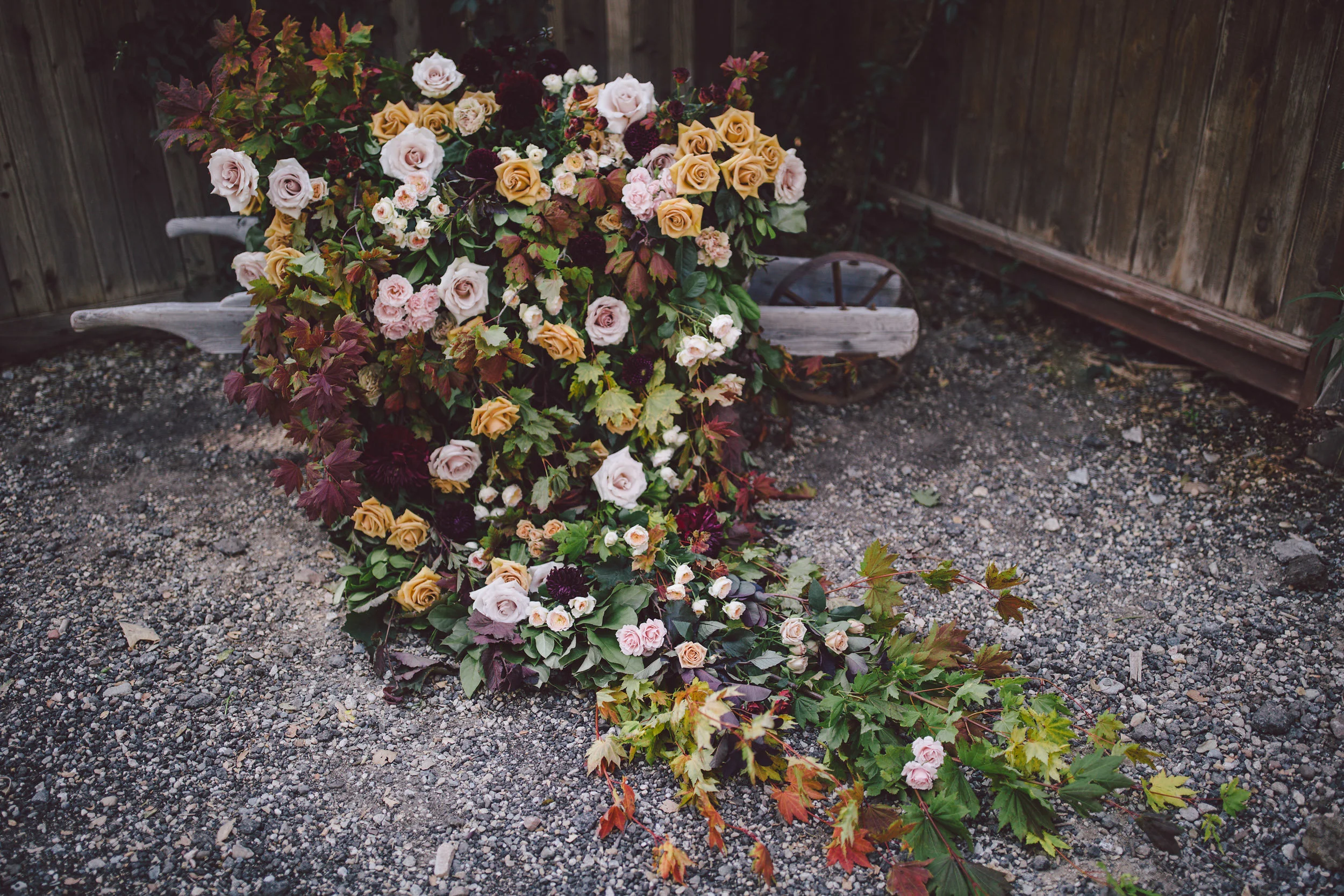 fall bohemian wedding flowers in wheelbarrow