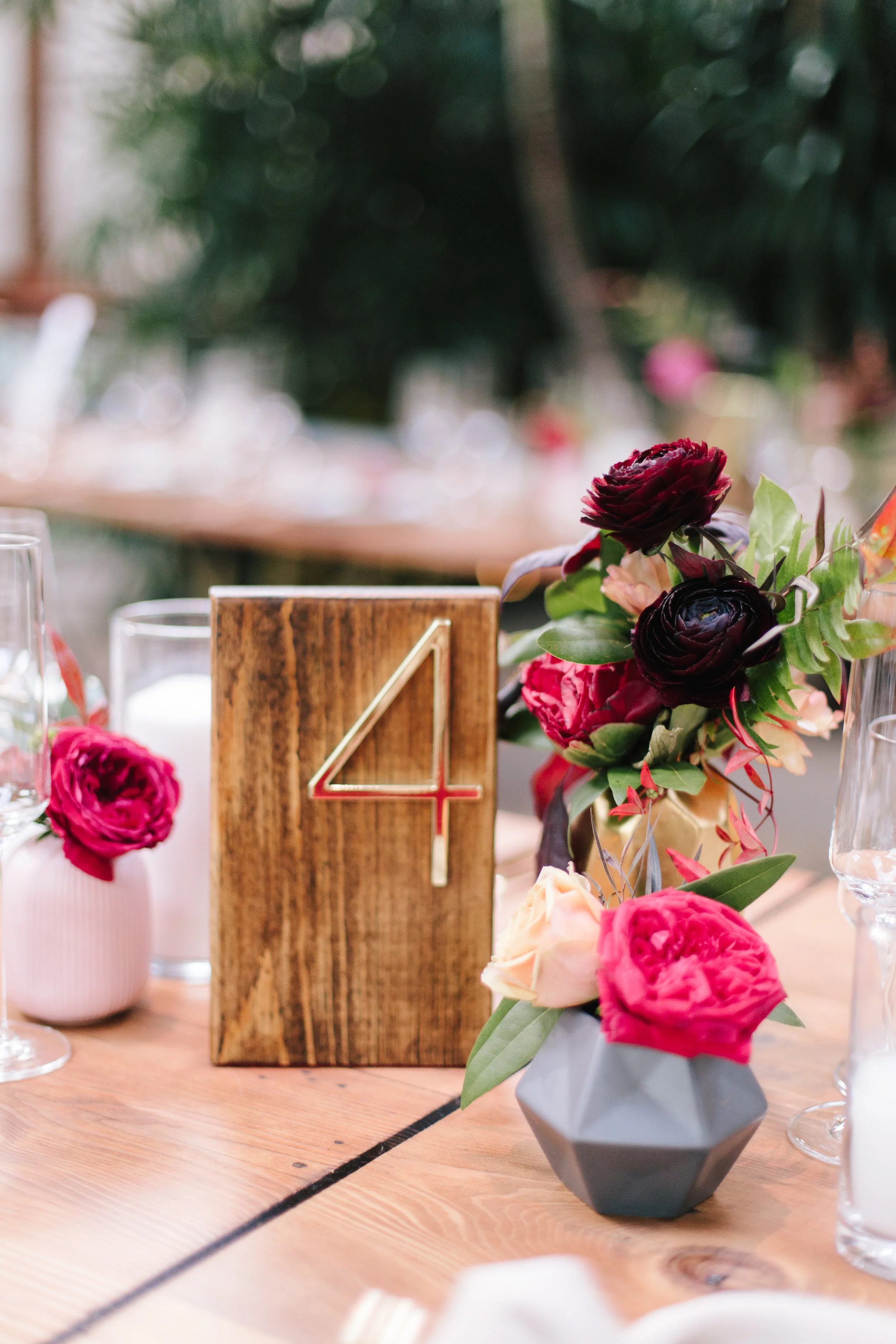 peach, fuschia roses and chocolate ranunculus in small geometric bud vases