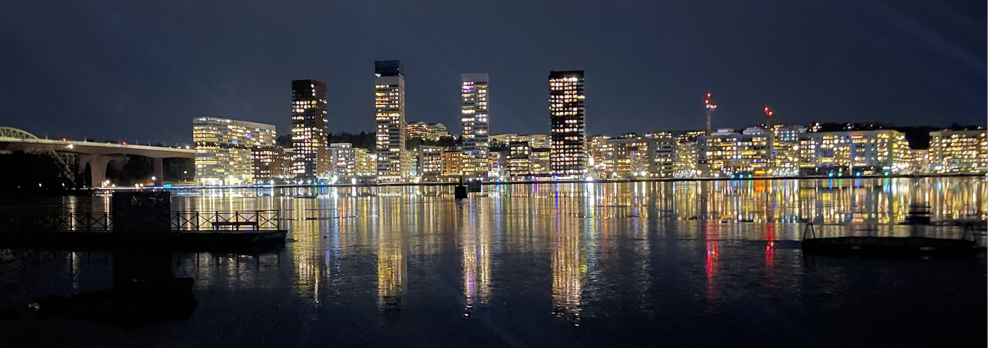 Sjövikskajens Skyline årets mörkaårstider är ett urbant färgcollage i vilken kajens ljuspollare lägger till grönblåa färgpunkter som följer kajens sträckning.
