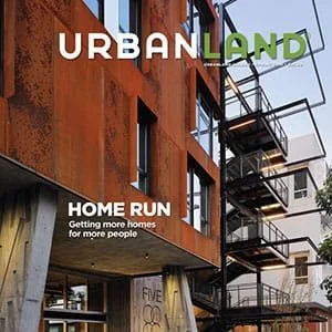 Close-up of a modern building with rusty orange exterior and fire escape, with text "Urban Land" and "Home Run: Getting more homes for more people."