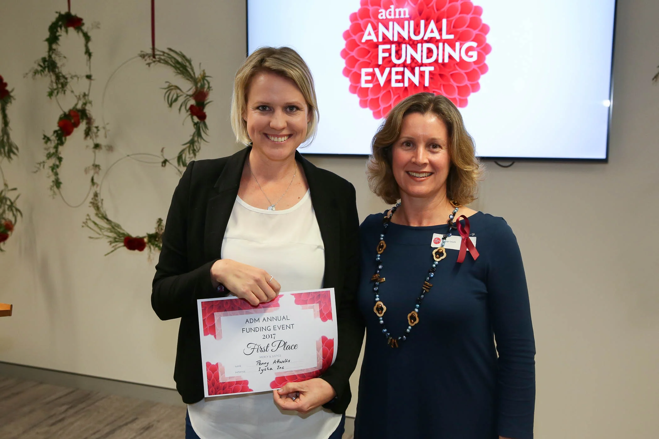 Penny Attwells (left) accepts her award from Margo Leach, ADM's Director of Mercy & Justice Ministries.