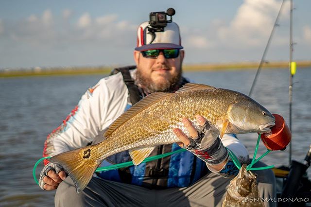 @bullets_broadheads_and_hooks grinning after he landed this hoss! #kayakfishing #redfish