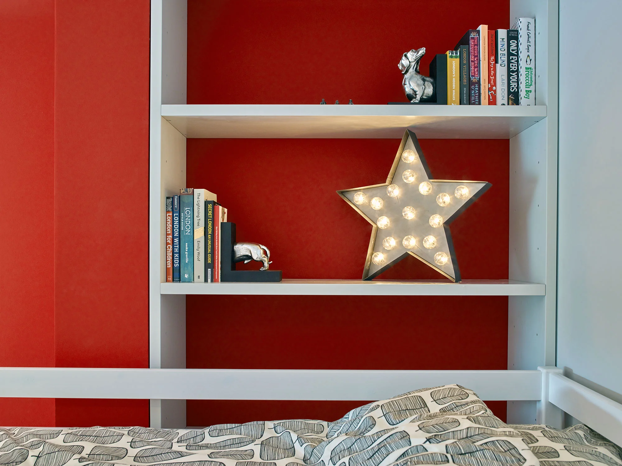 Vivid red walls in the children's bedroom off set the simple and minimal furniture.