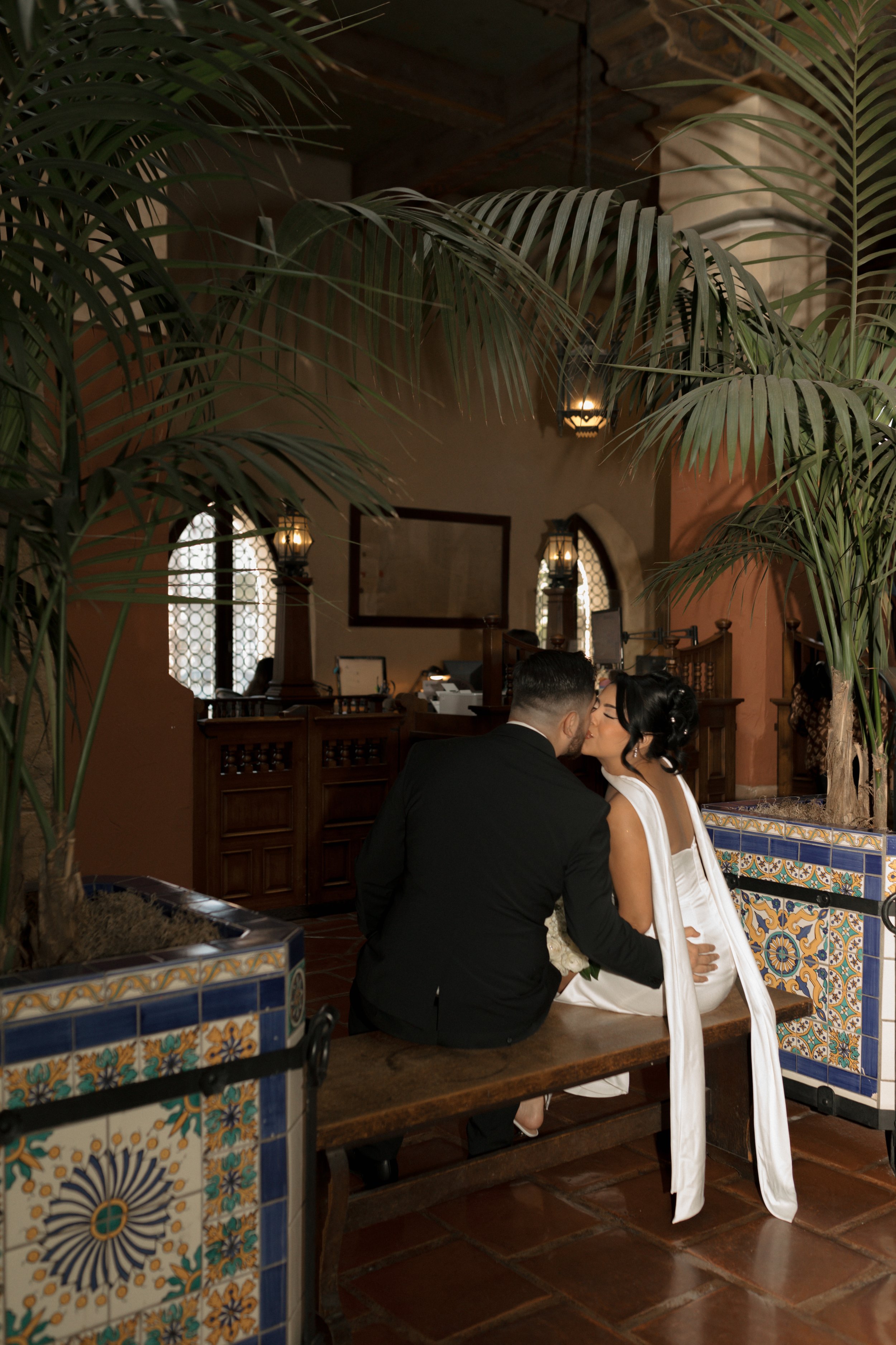 Couple kissing on a bench inside the Hall of Records at the Santa Barbara Courthouse during their elopement ceremony