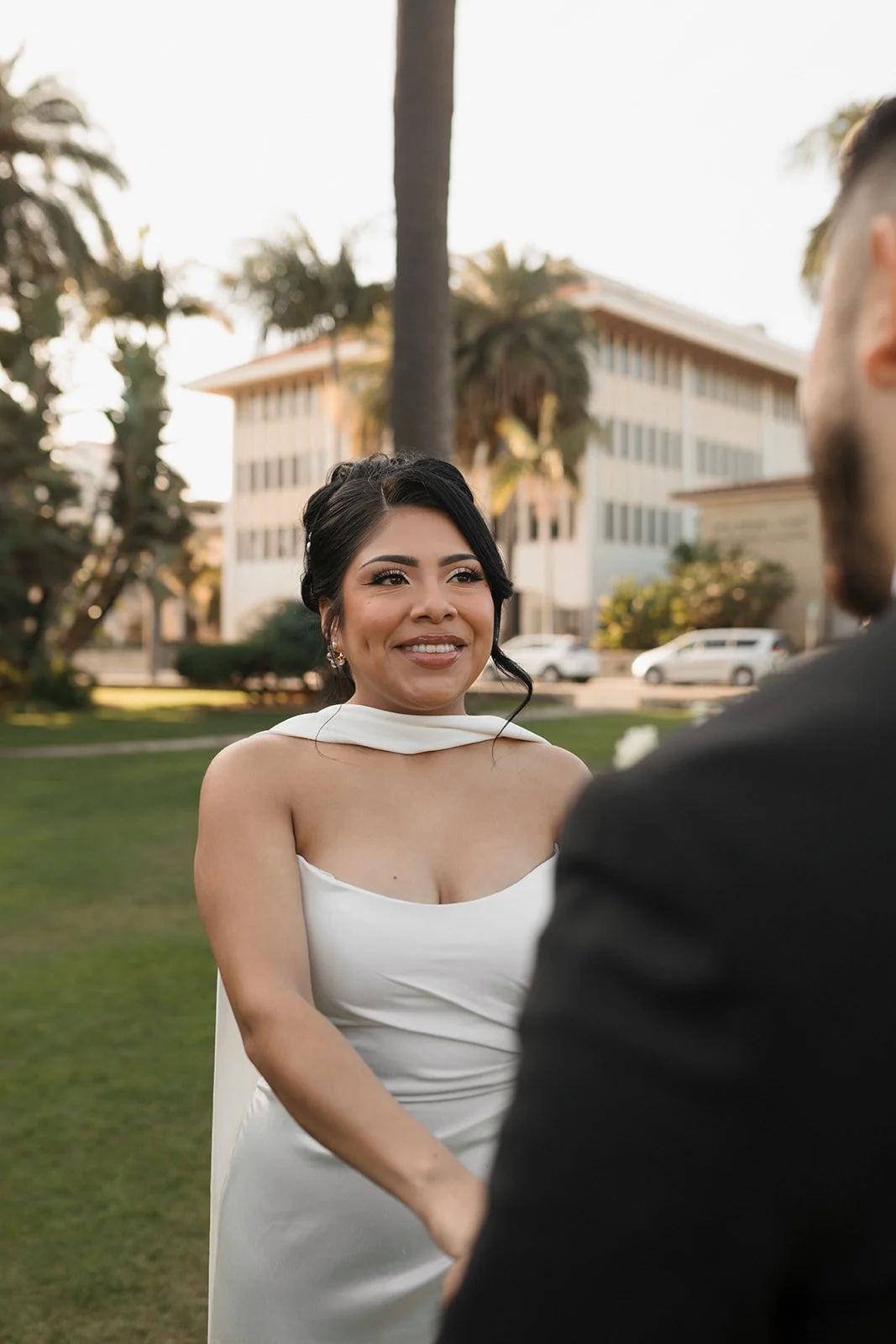 Groom’s POV of bride smiling at him while holding hands during elopement ceremony at the Santa Barbara Courthouse