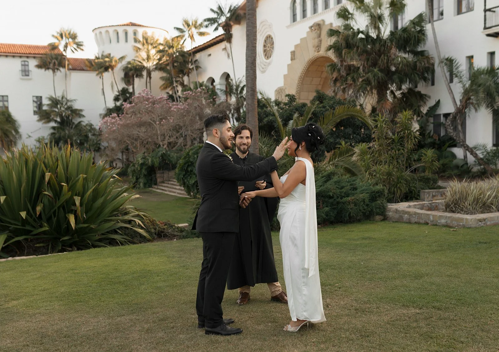 Groom wiping a tear from bride during ceremony at the Santa Barbara Courthouse Sunken Gardens elopement ceremony