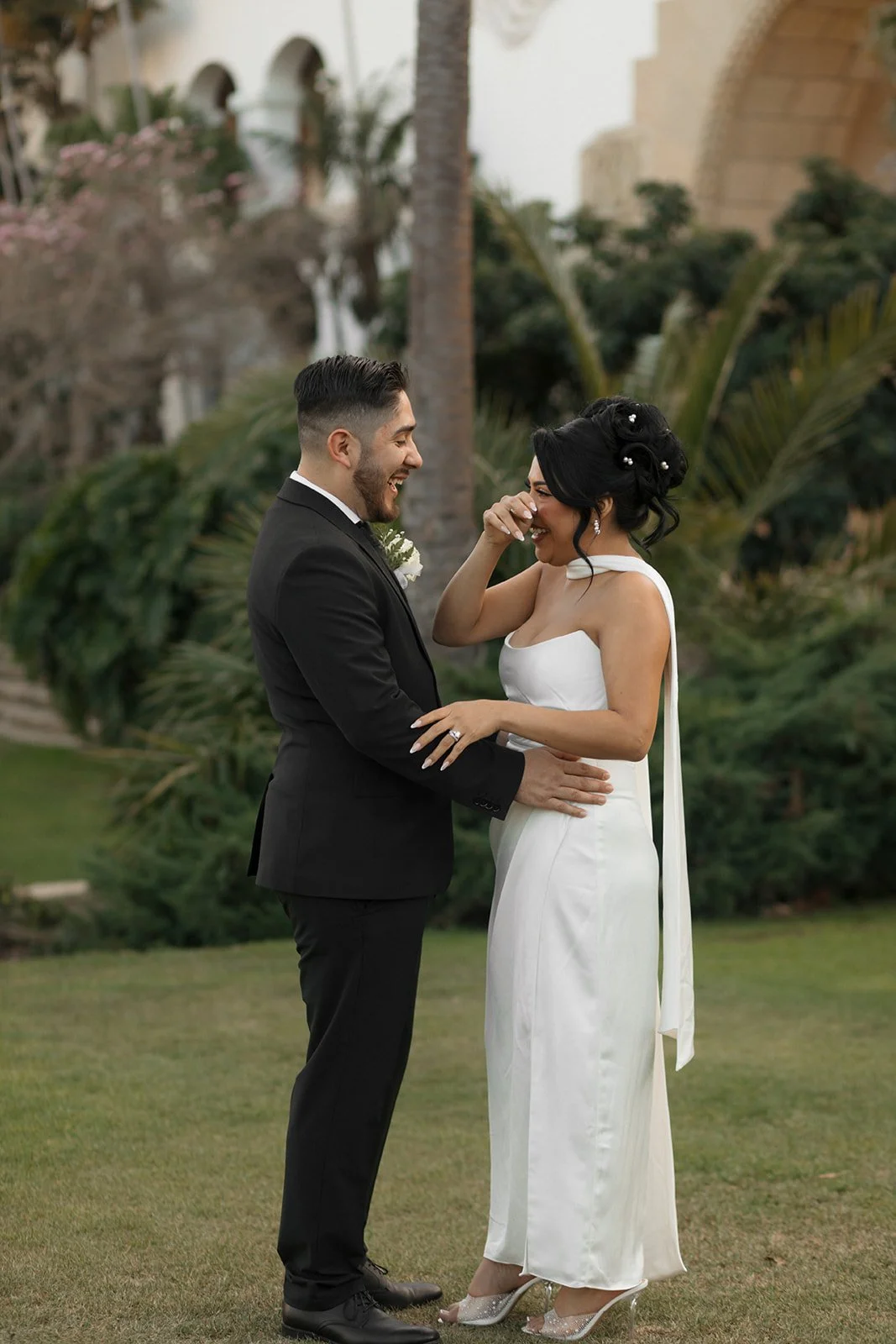 Couple embracing at the end of their ceremony at the Santa Barbara Courthouse Sunken Gardens, groom holding bride as she wipes away a tear