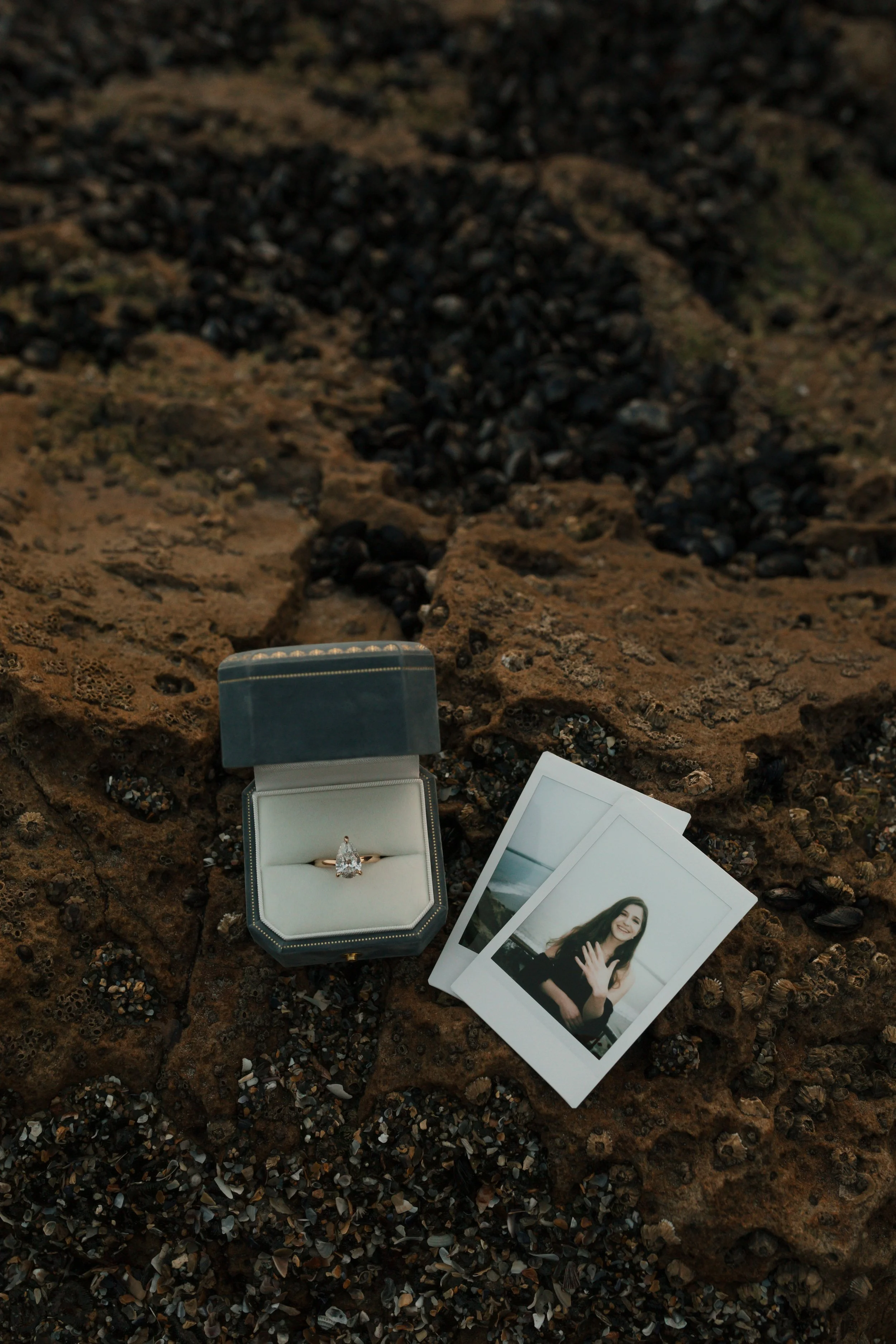 detail above shot of ring, ring box and instant film photos of girl showing off her ring from proposal in newport beach