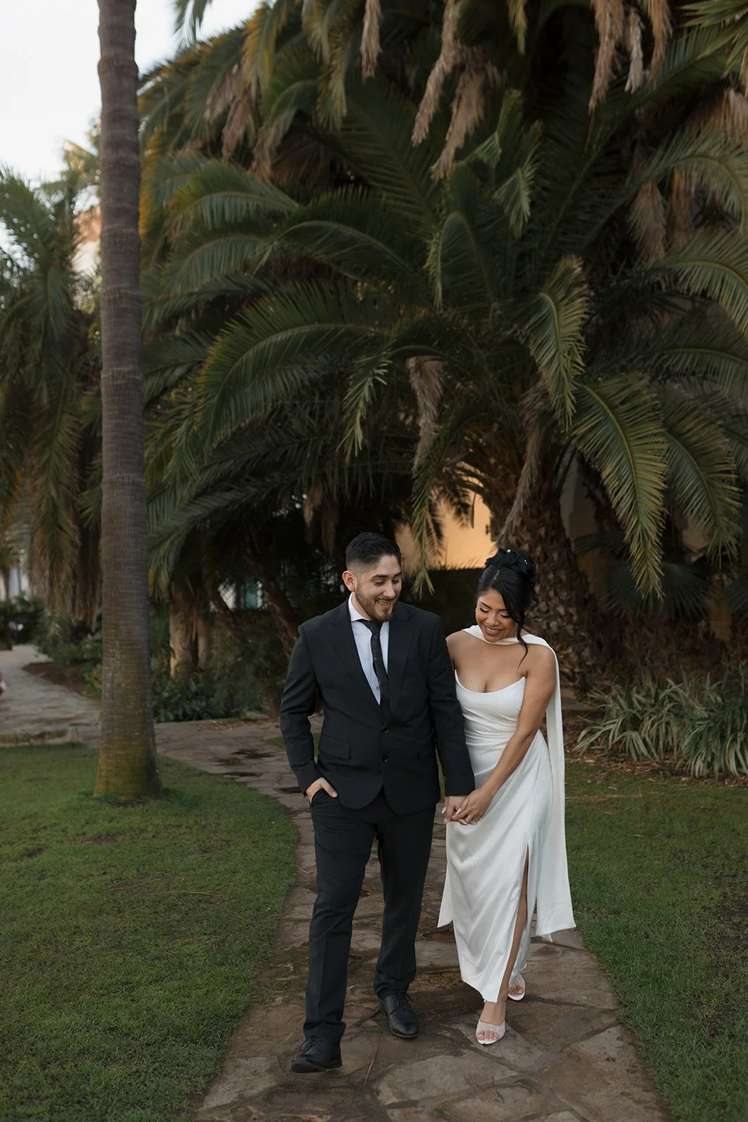 Candid moment of couple walking and laughing, leaning into each other during elopement at the Santa Barbara Courthouse Sunken Gardens