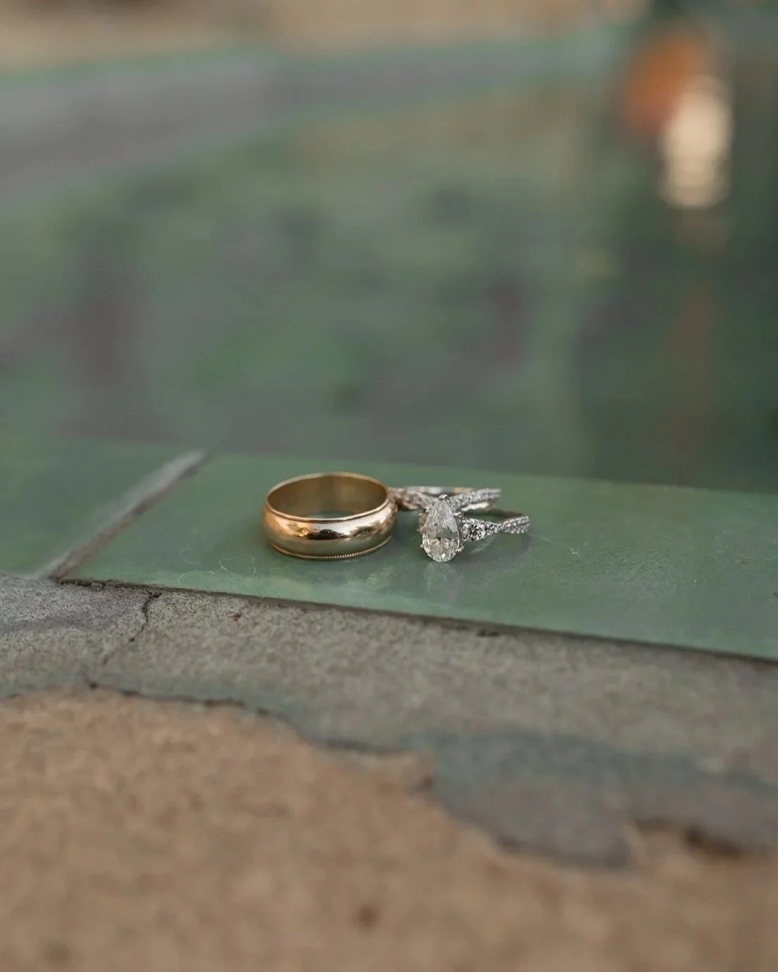 detail photos close up of wedding rings from bride and groom on the fountain tiles of the santa barbara courthouse