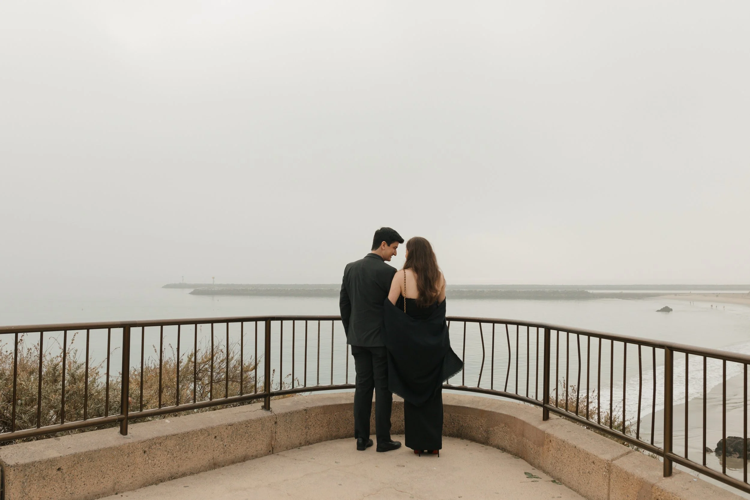 couple before proposal looking out at this lookout spot in newport beach with view of ocean