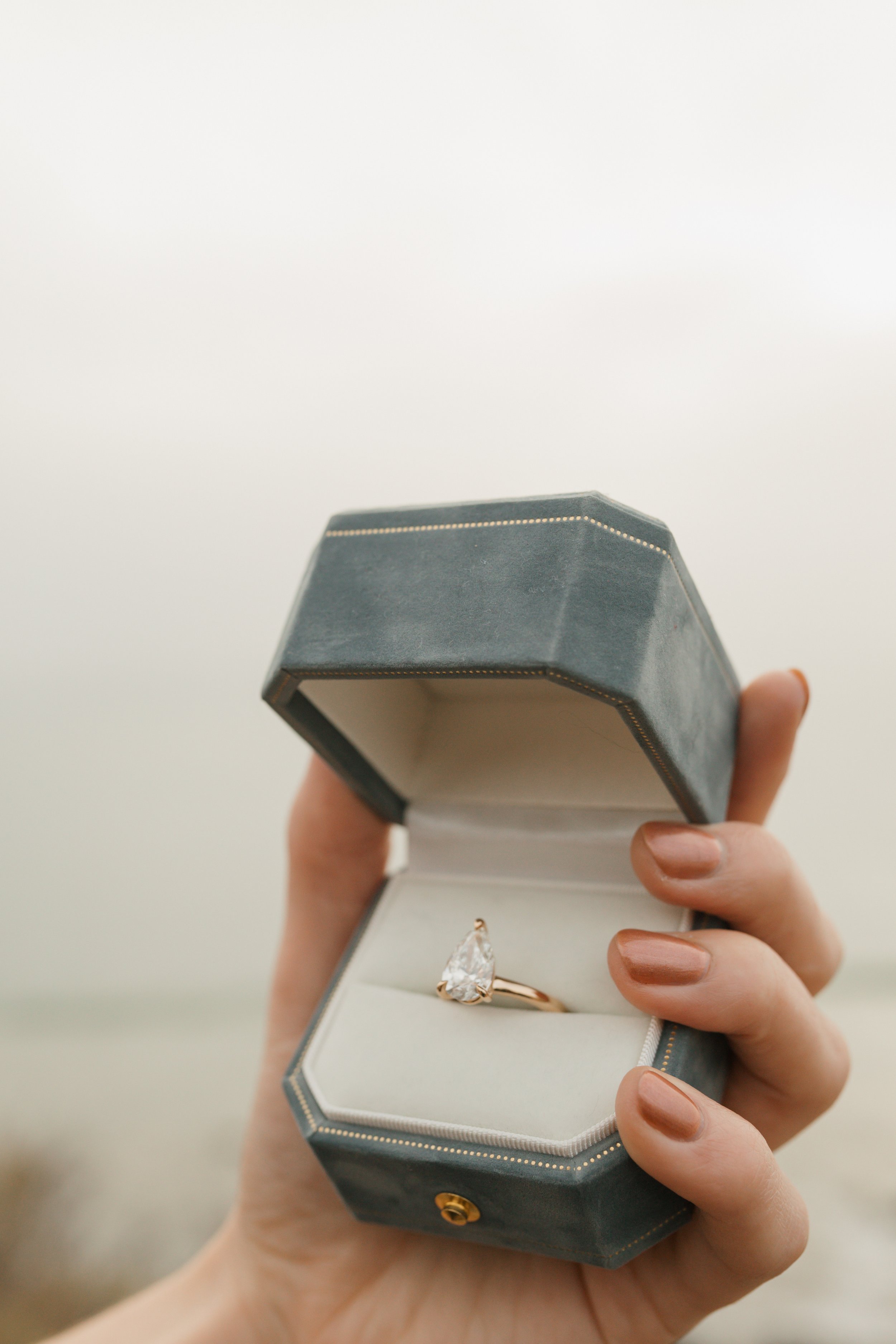 close up of ring in box from the prposal at the lookout in newport beach of nick the guys hand holding box