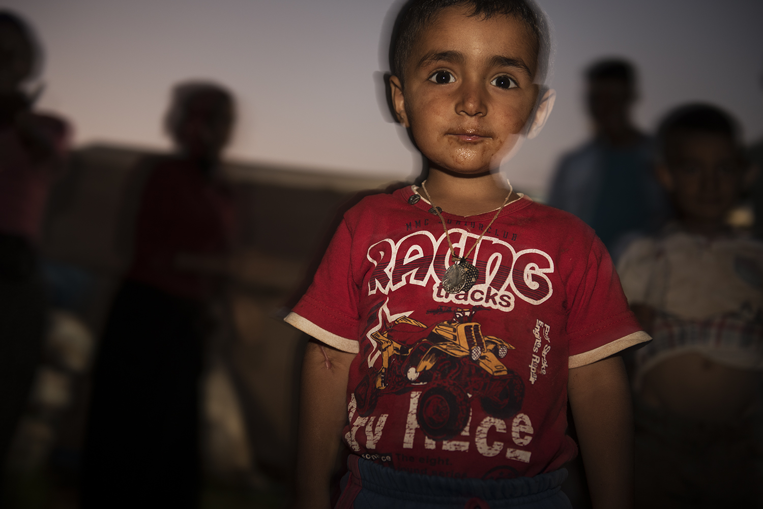 John Mohamed, a Kurdish child, poses for camera in informal refugee camp. Southern Turkey. 2015. ©Go Nakamura photography