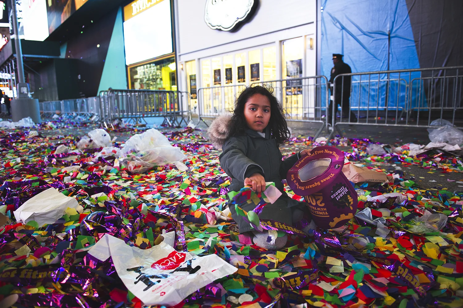 a girl plays with confetti what was used for New Year Countdown event in Times Sq, NY. 2016 © Go Nakamura photography