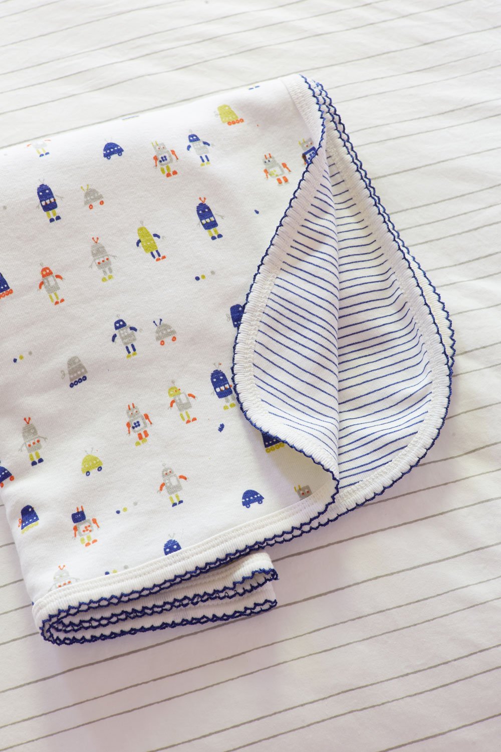 Close-up of a cotton baby blanket with our Robot March print by Little Auggie designed by Gen Burgess.