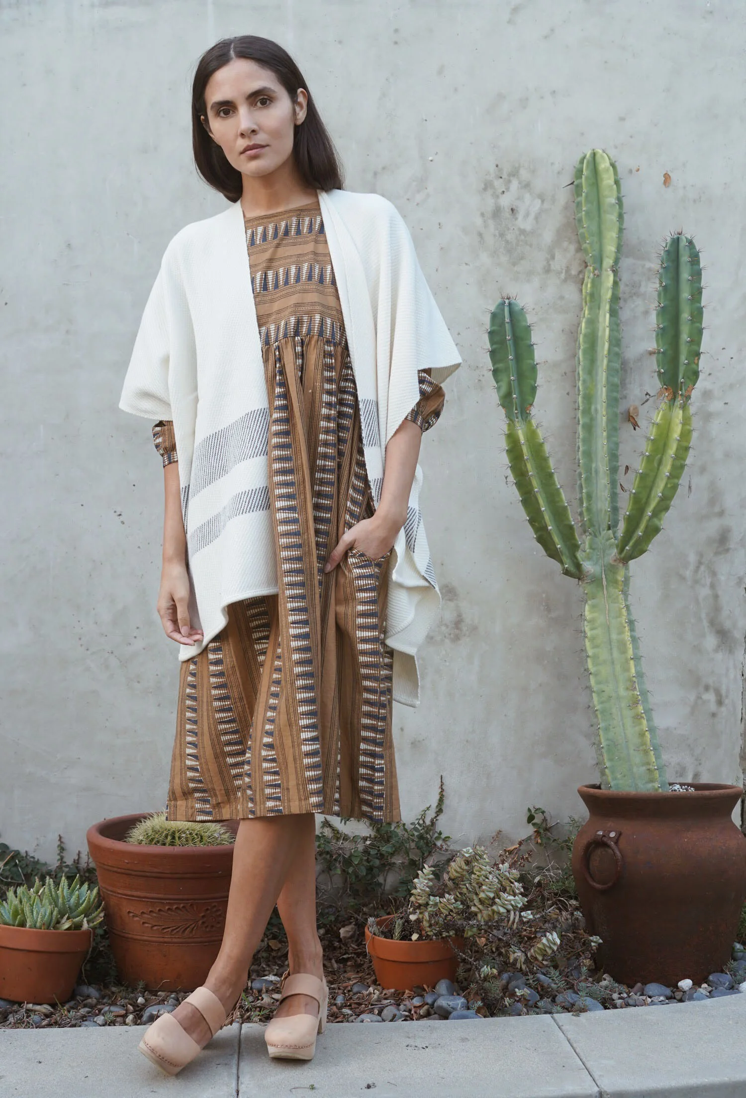 Kopal Kuku Dress in Mustard Strip + Maiyet Stripe Hem Poncho in Ivory + Zuzii Closed Toe Clogs in Natural.