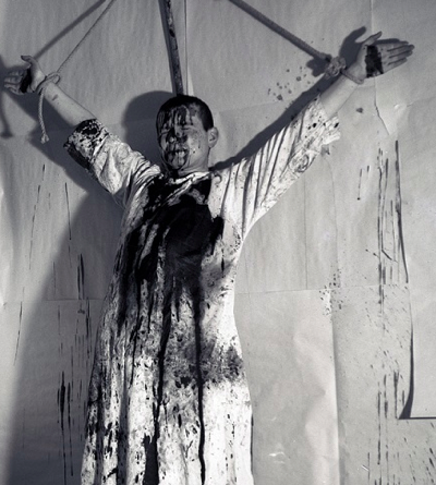 Hermann Nitsch, 1. Aktion 19.12.1963, Kreuzigung und Beschüttung eines menschlichen Körpers Wohnung Mühl.