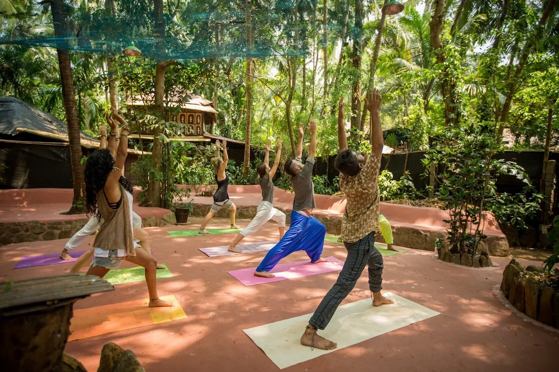Guests practicing yoga at Bhakti Kutir’s Ayurveda shala surrounded by nature in Goa