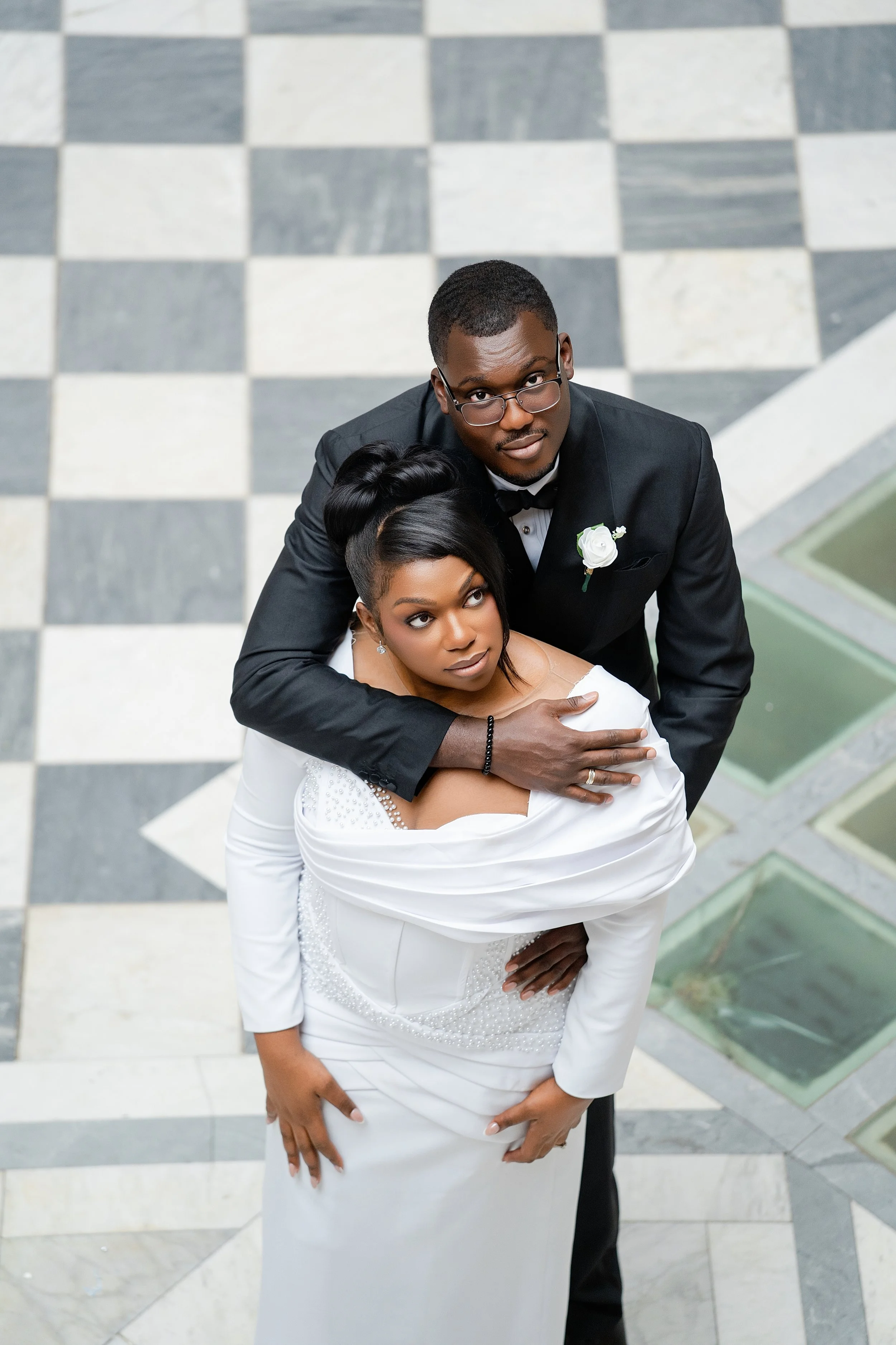 Bride and groom embracing in a high-angle wedding portrait on a patterned floor