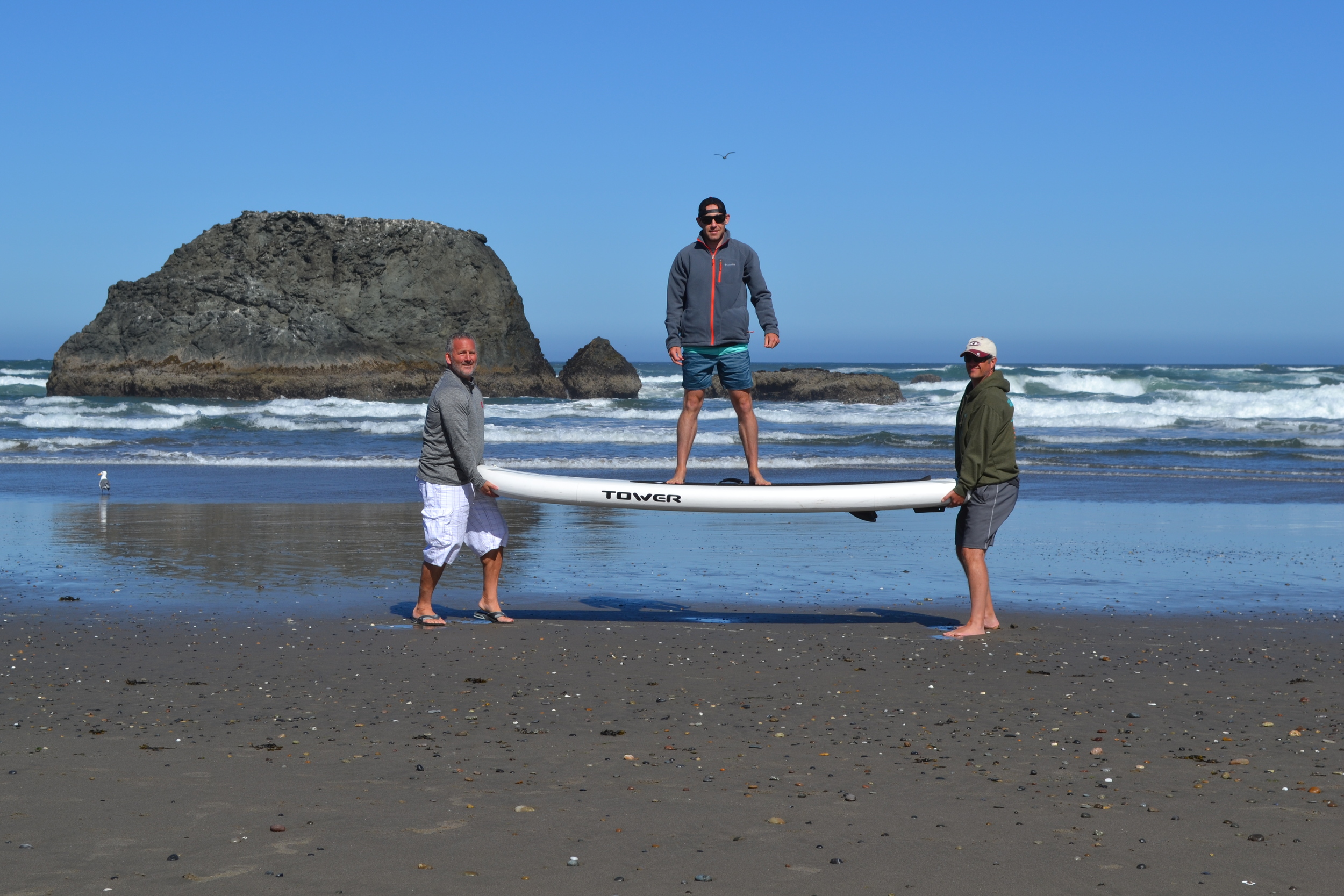 One of our co-founders Scott took the family to the Oregon Coast recently.  Somehow he was able to sucker Jeff and Rick into holding him and the board up so he could demonstrate just how rigid our inflatable boards are.