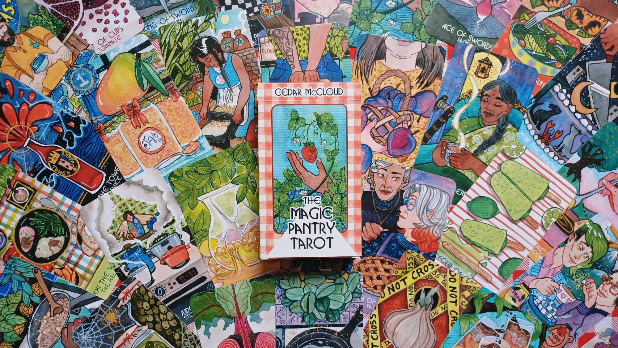 A picture of the Magic Pantry Tarot box sitting on top of an array of colorful cards.