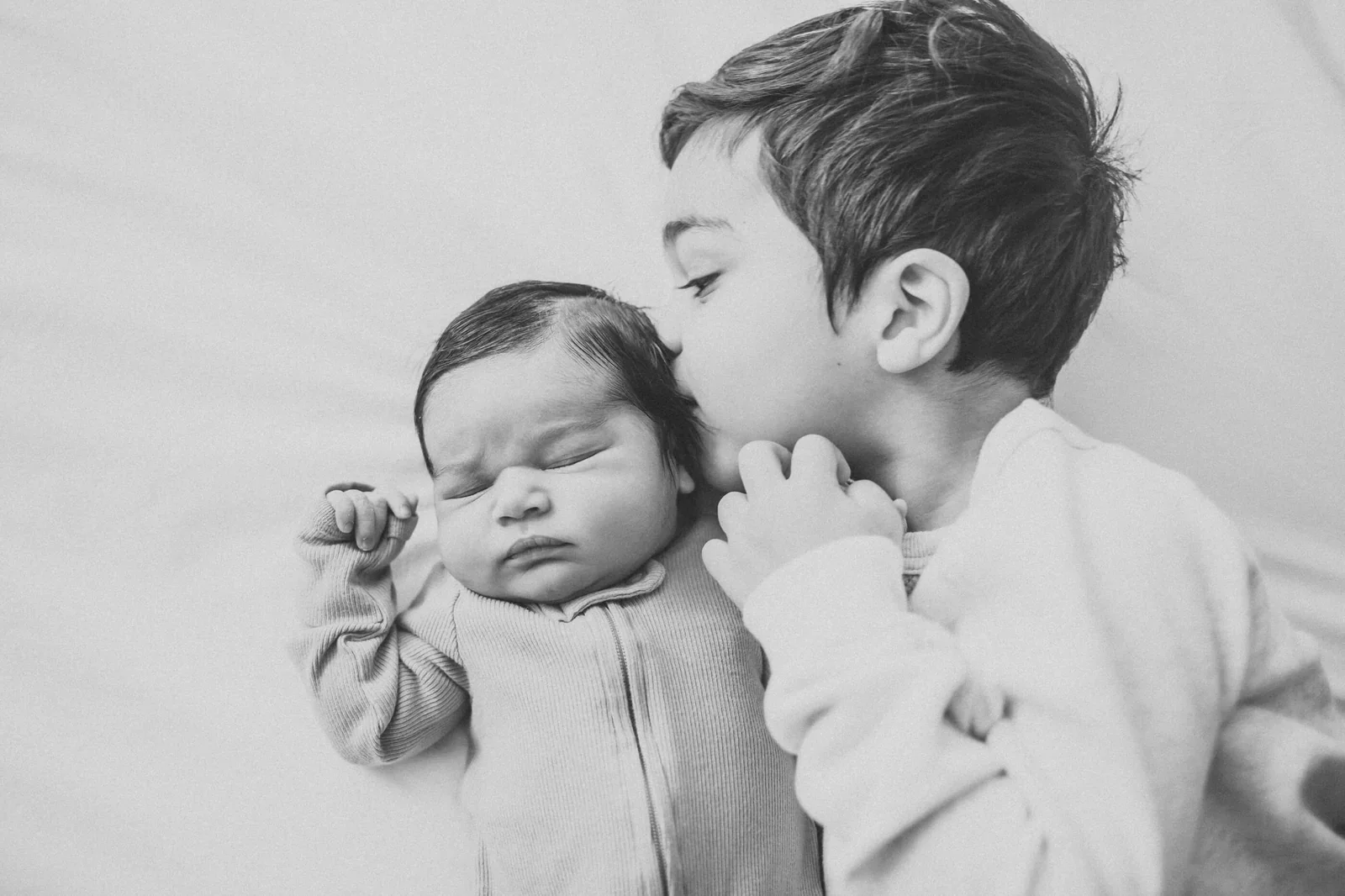 siblings together during newborn birth photography session