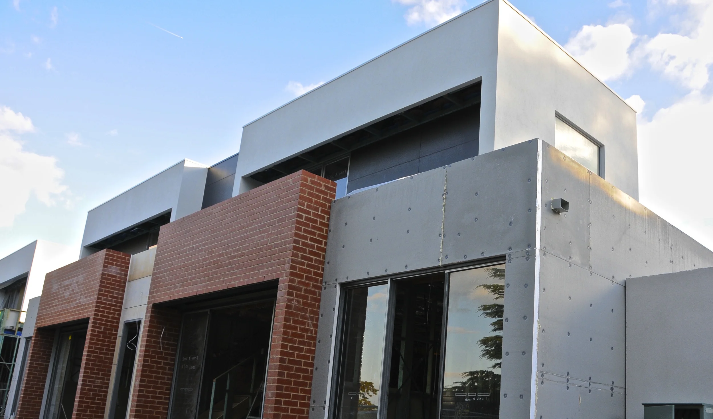 Front elevation: cladding in progress on ground floor.