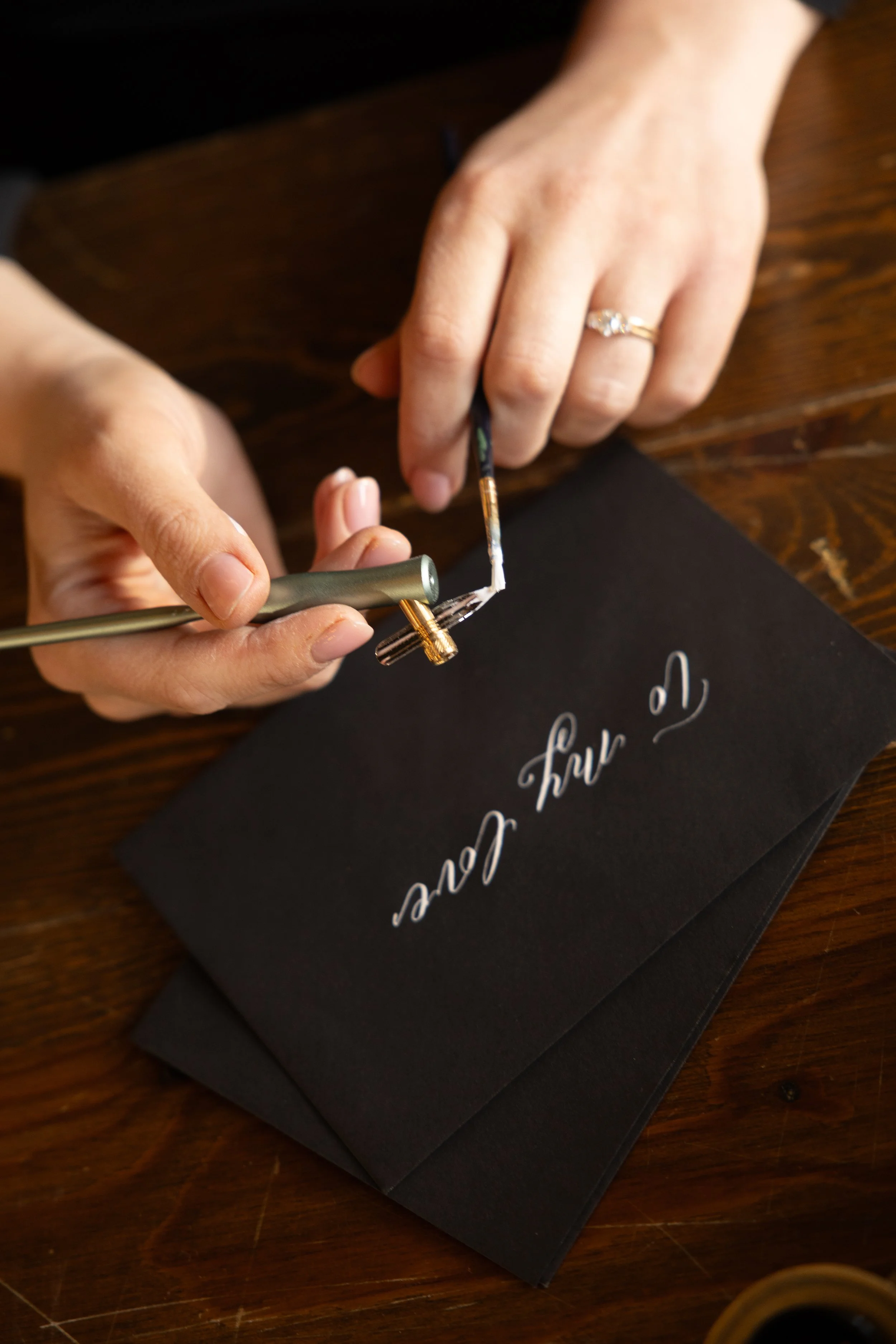 Calligrapher writing on a gift card at a wine retail event