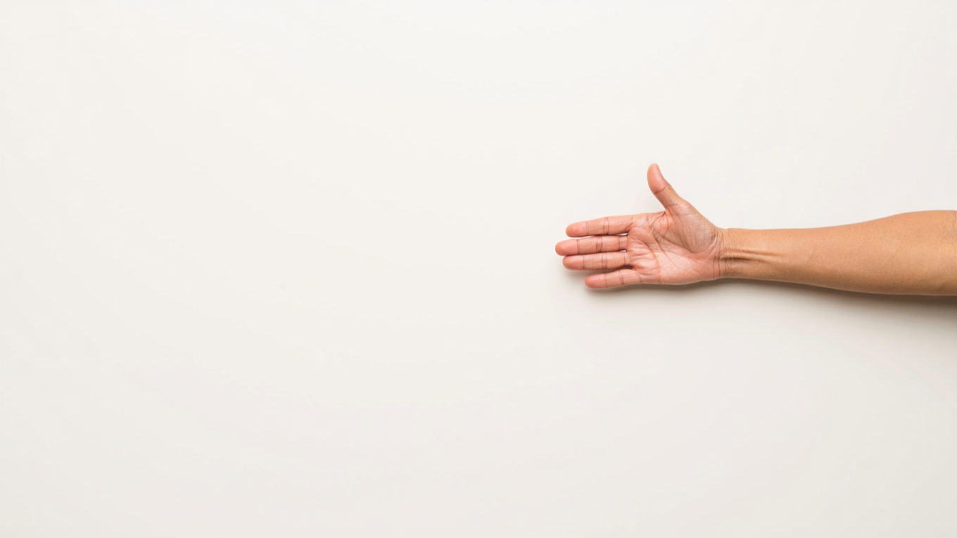  A clean, minimalist, high-angle overhead shot of a person's bare right arm and open hand, palm facing upwards and slightly outwards. The arm extends from the right edge of the frame, with the hand fully visible, fingers slightly spread. The skin is 