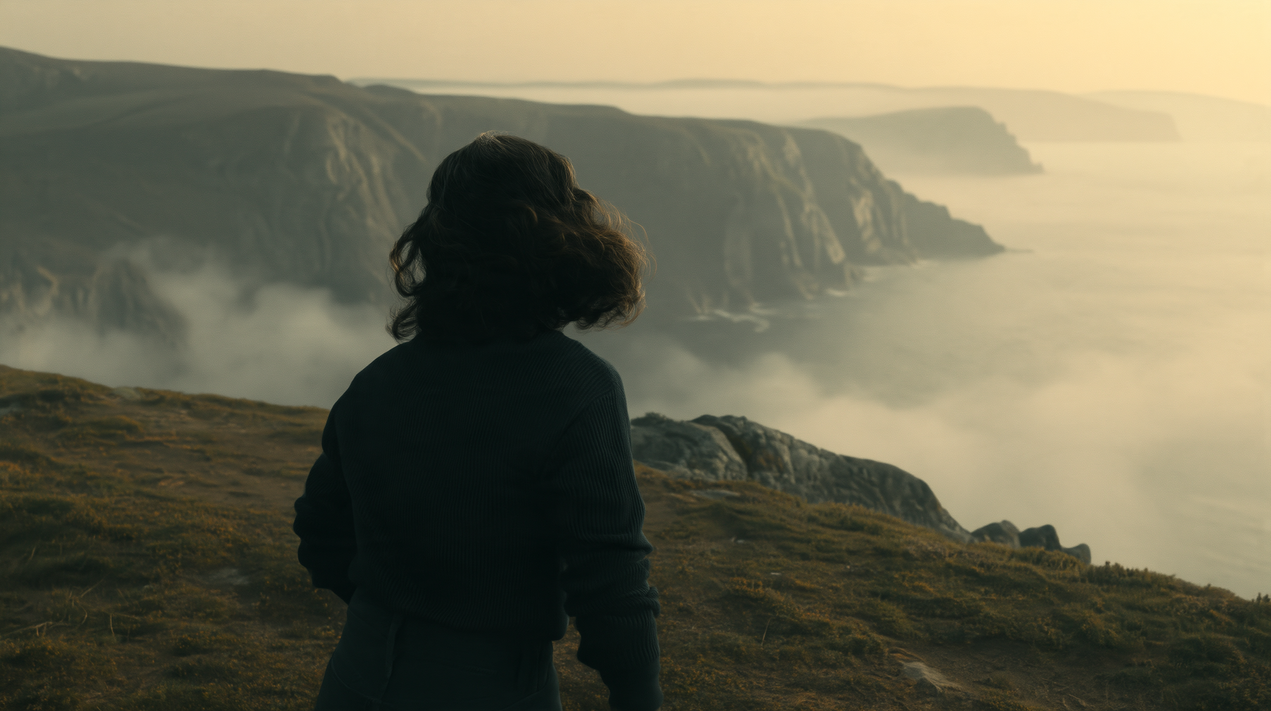 Curious Refuge tutorial cliffside image reference: a person seen from behind overlooks a misty coast