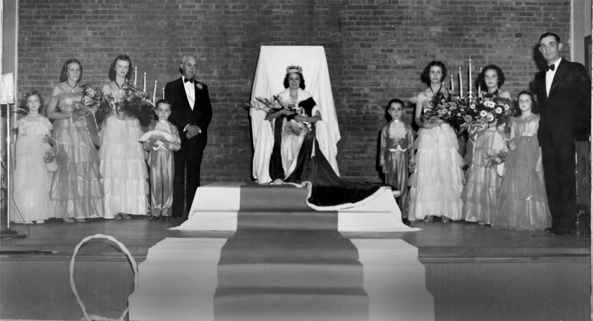 First Mimosa Festival – June 23, 1938. Left to right: Sarah Lou Davis, flower girl; Nancy Harbison and Ann Huffman, attendants; John Wilson, crown bearer; Benedict Bristol, Mayor of Morganton who crowned the Queen; Margaret Chaffee, the first Mimosa Queen; David Wilson, page; Elizabeth Sharpe Erwin and Betty Gaither, attendants; Martha Fuller Chaffee, (sister of the Queen) flower girl; Frank C. Patton, master of ceremonies. Photo contributed by the Burke Co. Pub. Library