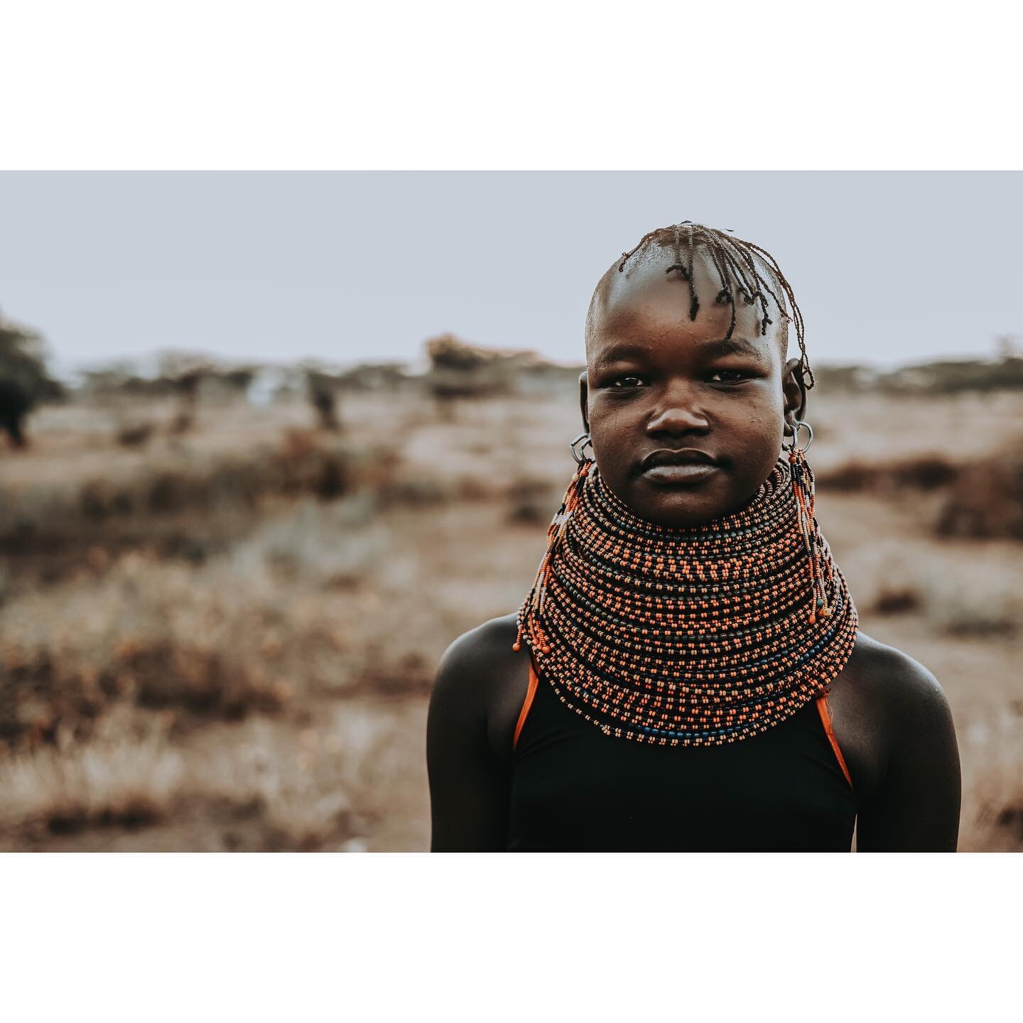 A young woman named Ilayok takes a break from gathering wood before helping repairing a boma fence. Like many cultures, Turkana women in this village are the architects &amp; the backbone of the community - in charge of constructing the community&rsq