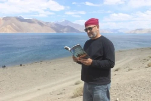 Bangong Lake @ 14,000 ft near the China border. An adventurer reads The Oasis Within for even more inspiration than the setting provides.