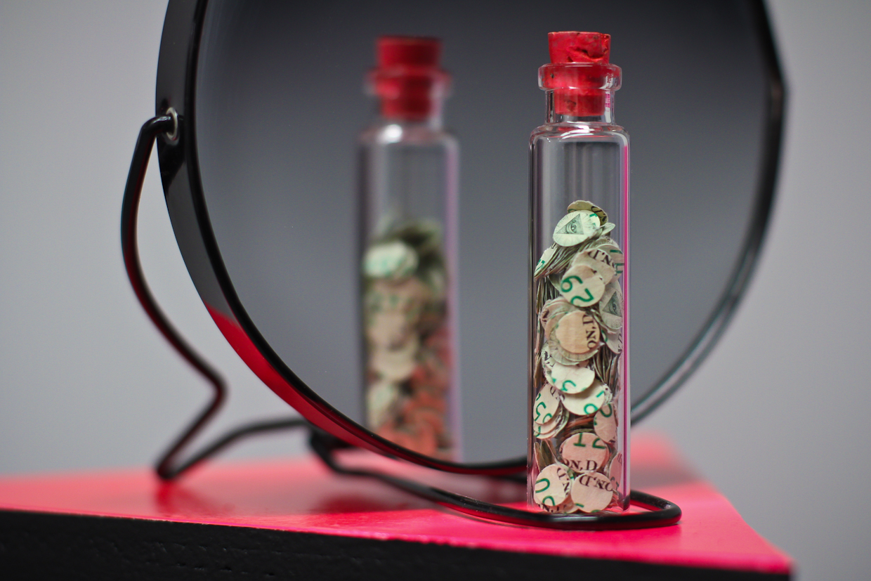 USD306 (2011) - a vial of 306 punch-outs from American one-dollar notes