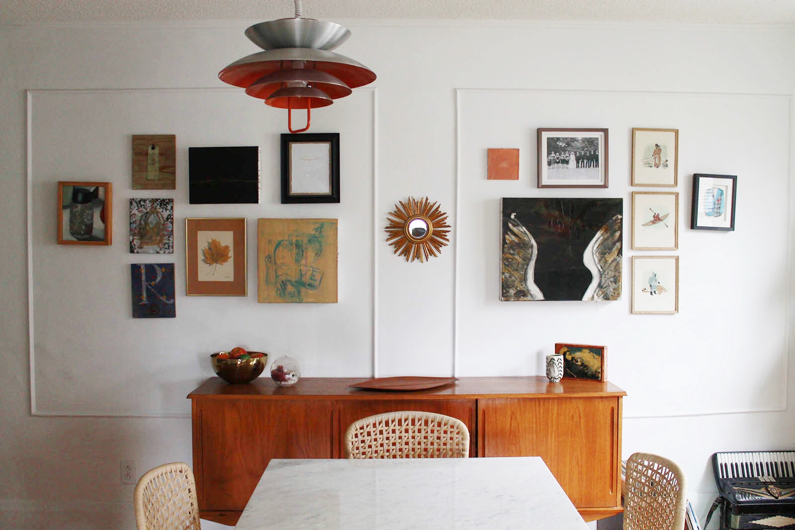 Our dining room. I got the Knoll table as commission years ago when I worked at a mid-century Modern furniture store. The vintage credenza was a gift to ourselves after our wedding, and the chairs were a clearance find at IKEA, which satisfied my desire for chairs with caning. We assembled the gallery wall from pieces that we love by our artist friends and some are by Mike, while others belonged to my grandparents. The mirror is an antique we picked up here in Toronto one day.