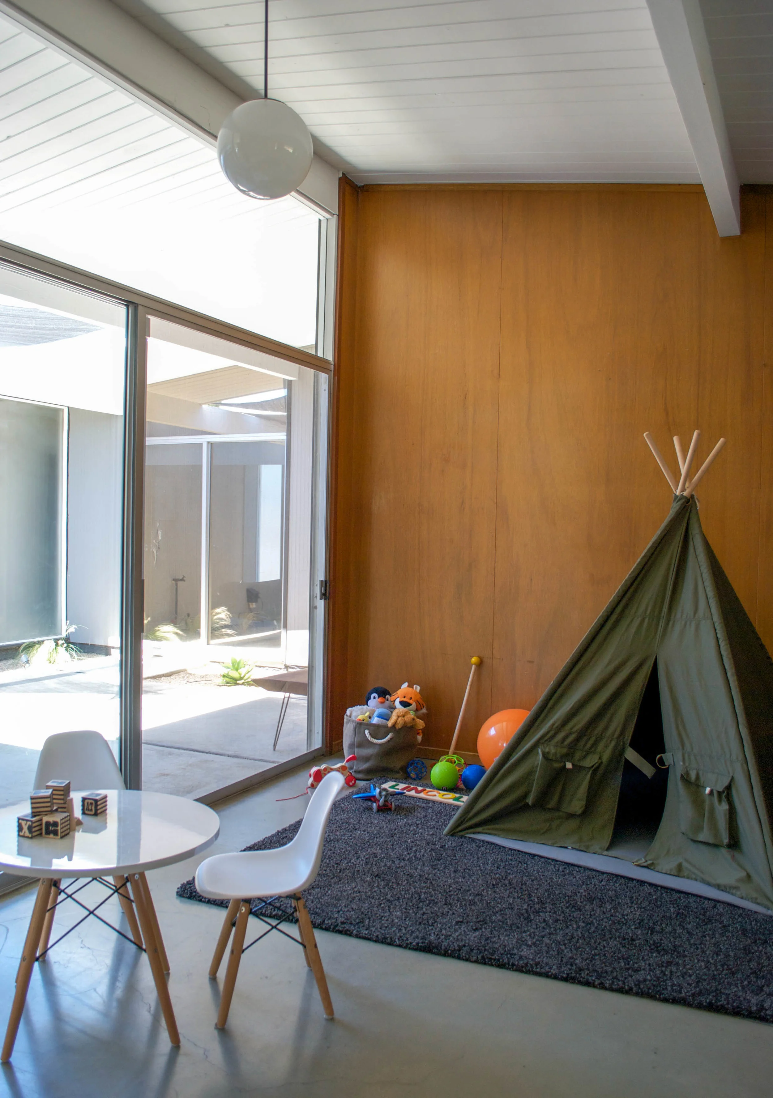 Lincoln's playroom is furnished with a modern table and chair set, as well as a spot to camp out and get cozy.