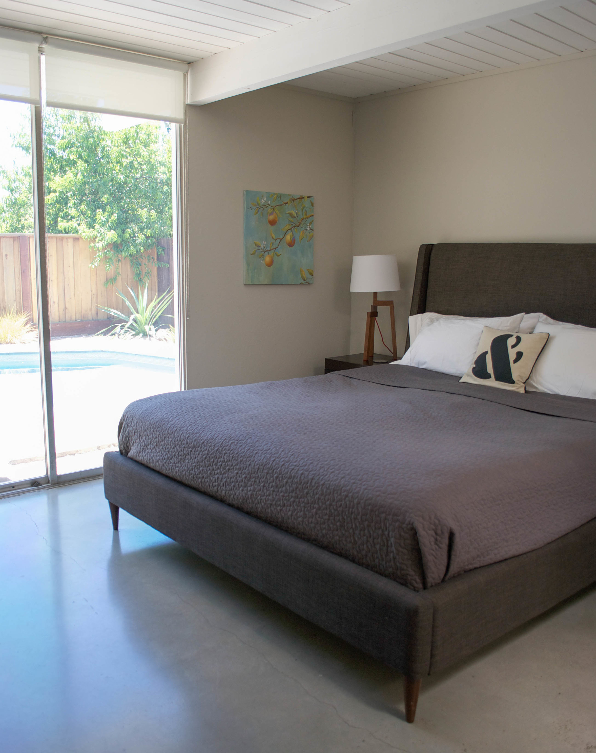 The master bedroom with a clear view to the pool. Laura worked so hard to refinish the floors, I'm glad they have not been covered by area rugs.