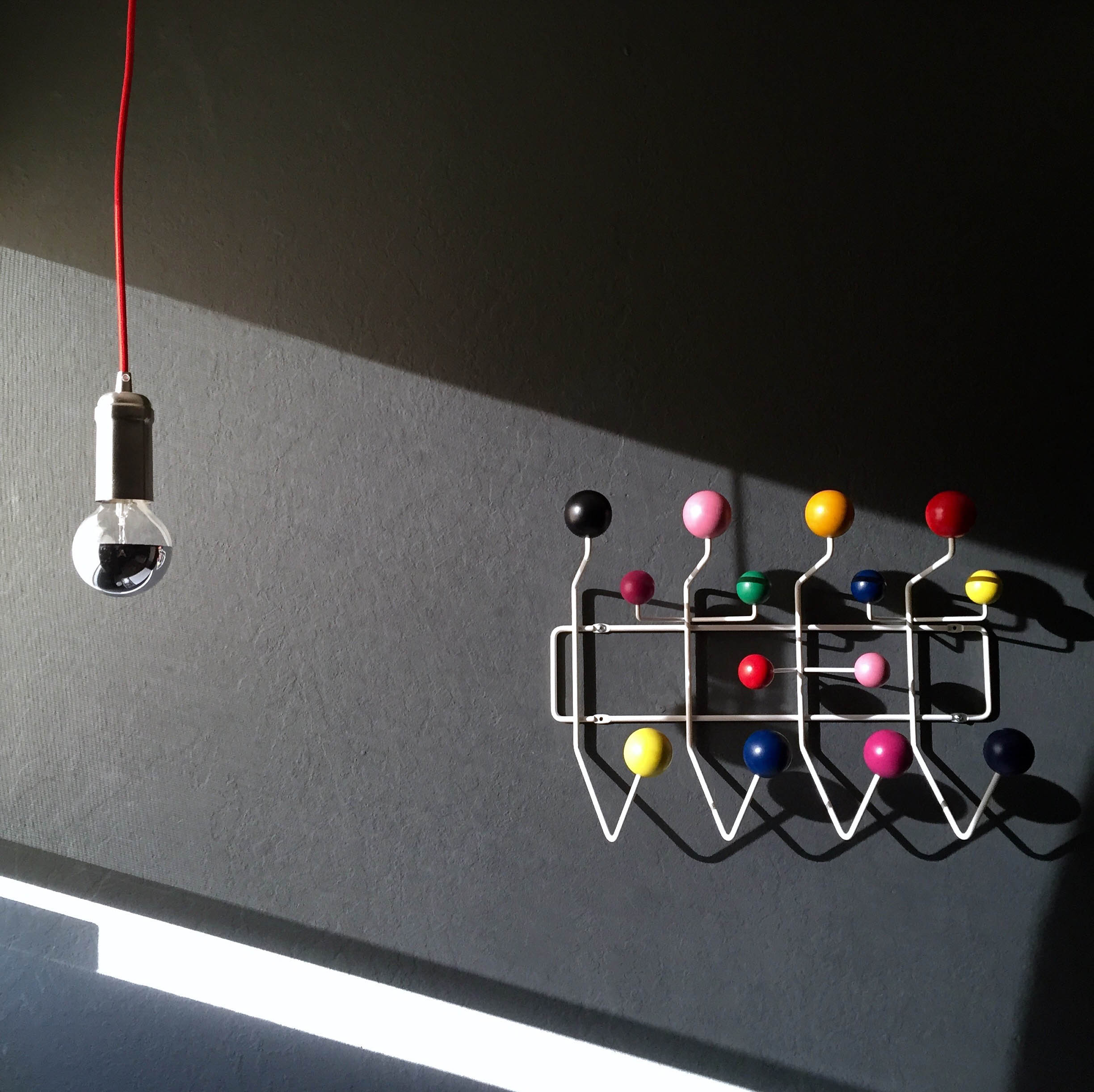 Is it crazy that I'm jealous of a toddler's bedroom. The Eames Hang-It-All hooks are the perfect pop of color on this dark grey wall.