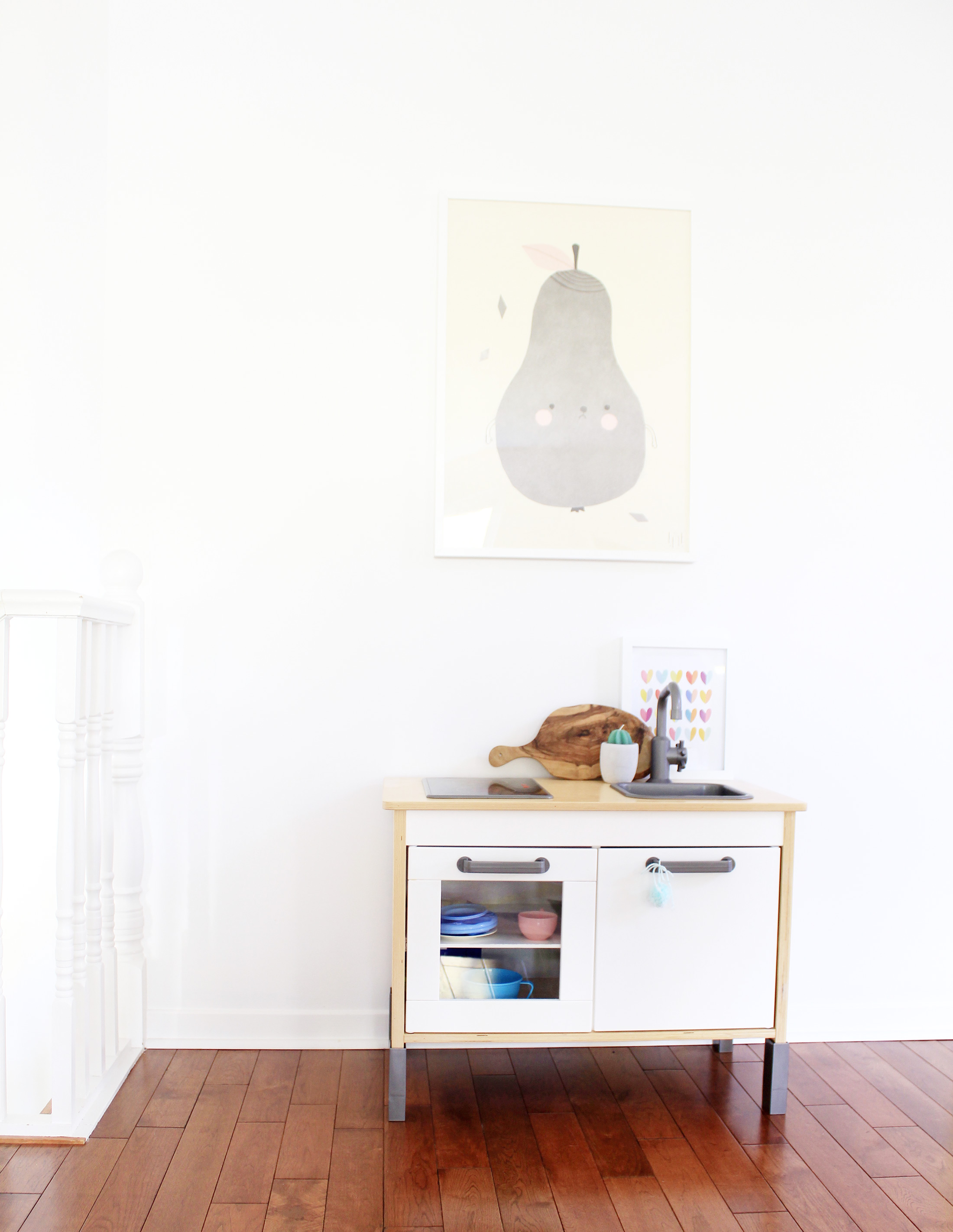 A framed print fits in with the living room decor and has a theme her daughters will enjoy. The placement of it is perfect here.