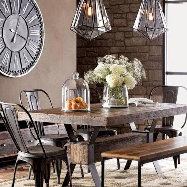 Sharp, edgy and strikingly stylish. The vintage charm of the large Roman clock and ancient stone wall is balanced with the sleek metal furniture and geometric pendant lights. Just add a bunch of blooms to soften the edges. 
#RenoGuide #InteriorDesign #DiningRoom #CityLiving #Rustic #Geometric #Industrial #Inspo #DesignInspo
