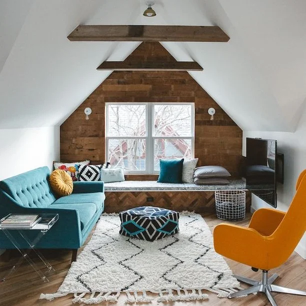 Reinvent your attic from boring to stunning! Bond with the whole family and enjoy your favourite movies or TV shows in this cosy attic retreat. The white interior is well-balanced with the sofa in a lovely shade of turquoise, while the zig-zag patterned rug and colourful footstool add a playful vibe to the room. The brick wood wall and exposed beam ceiling give the room its laidback styling. 
#RenoGuide #Goals #LivingRoom #LoungeRoom #Mustard #ColourScheme #ColourTheme #InteriorDesign #Comfort #Style
